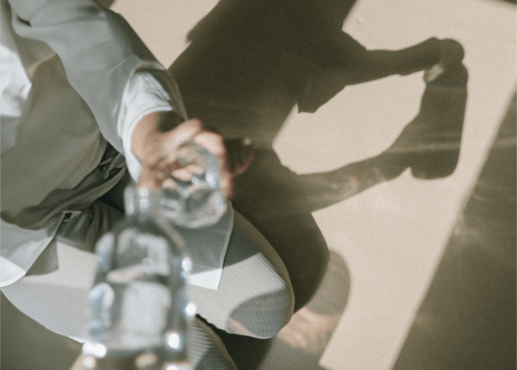 A man in a suit sitting down pouring a glass of water